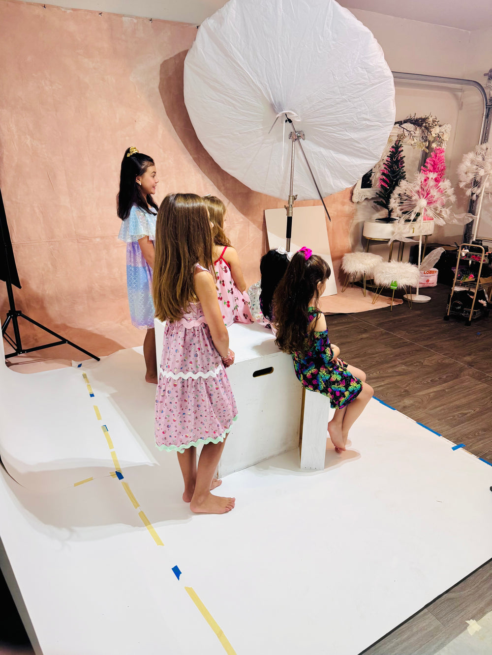 Behind the scenes at a Fragile Eccentrics studio photoshoot with children in colorful dresses
